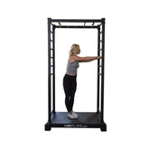 Woman performing a forward arm stretch on the VibePlate VibeStretch vibration platform, engaging in flexibility training